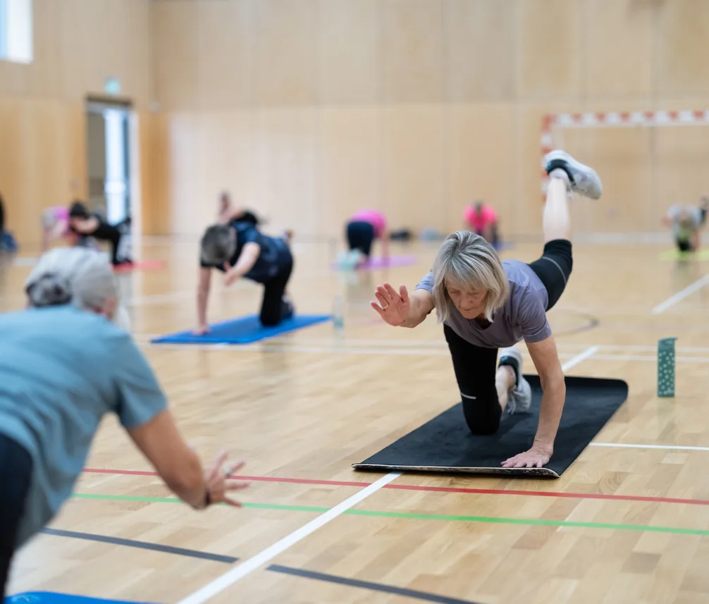 Sports hall at Menzieshill Community Hub, with goals at the end, during a fitness class
