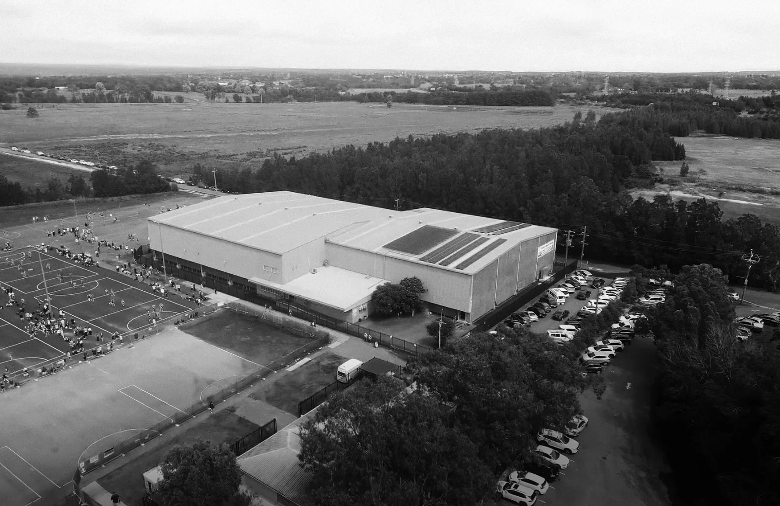 Aerial view of the Illawarra Sports & Community Precinct stadium building and outdoor courts, Berkeley