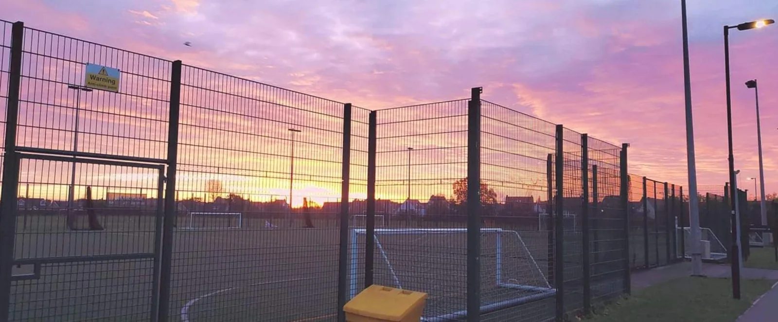 Fenced pitch at Burnholme Sports Centre at sunset